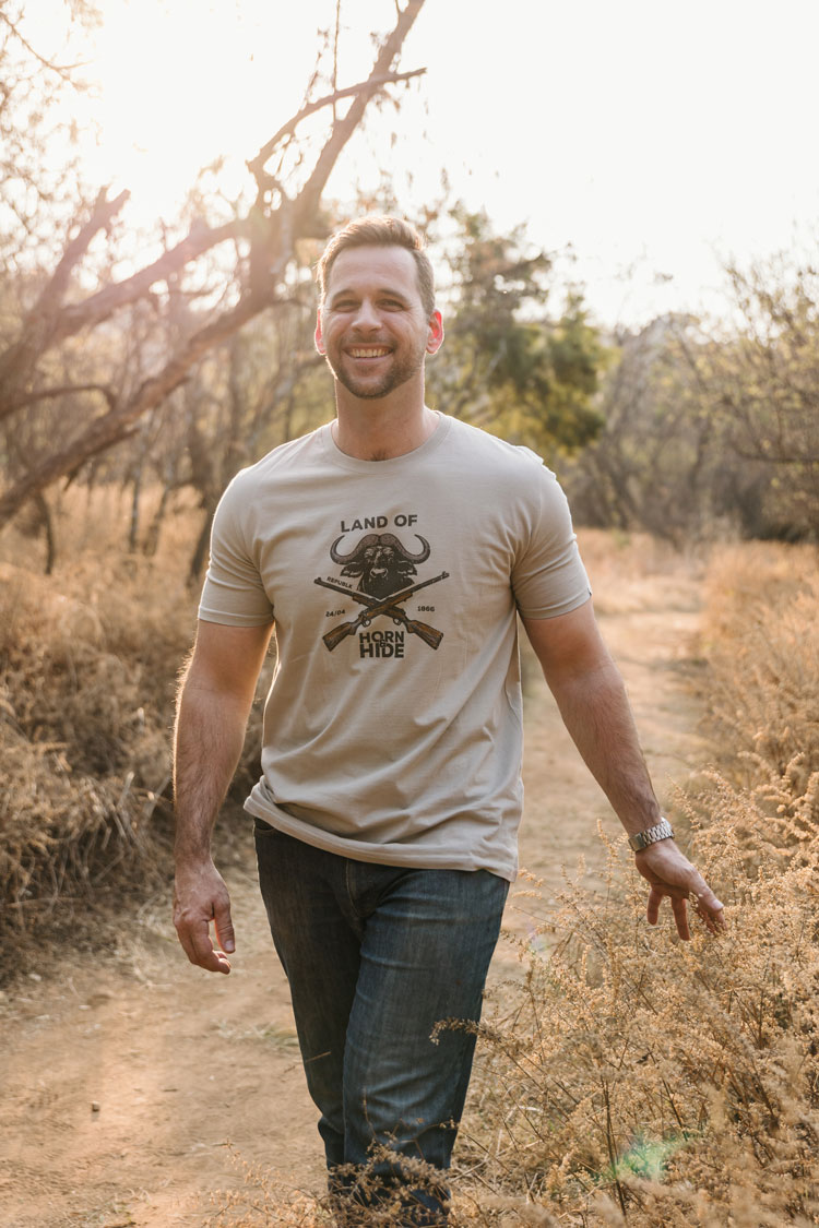 Man in a sand-coloured REPUBLK Land of Horn & Hide tee in the bushveld