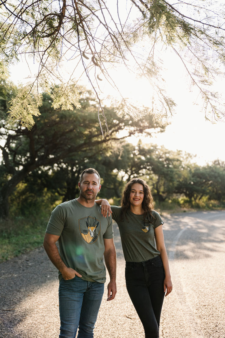 Couple wearing olive REPUBLK tees under a thorn tree